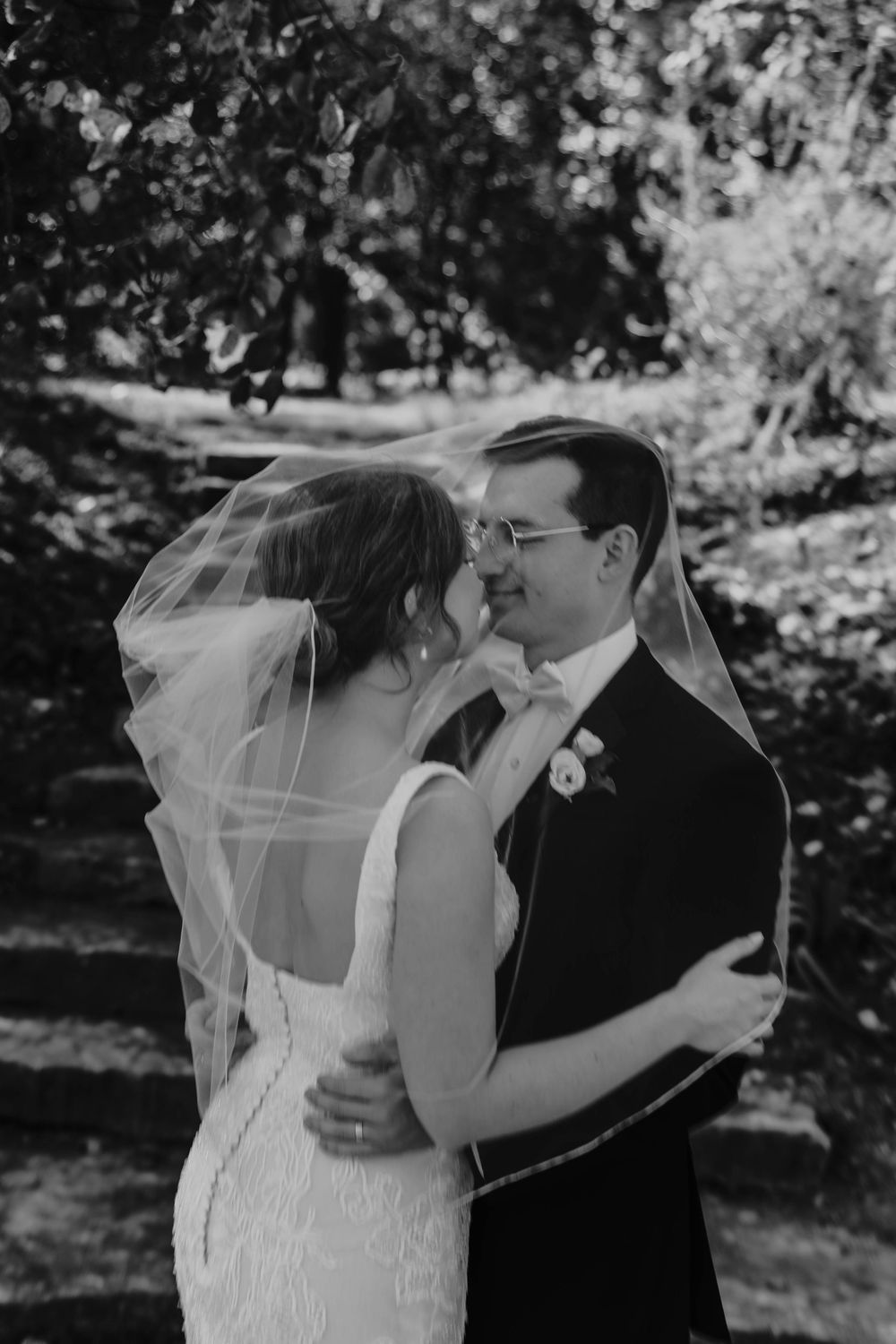 Black and white wedding photos showing romantic moments between newlyweds in an outdoor garden setting.