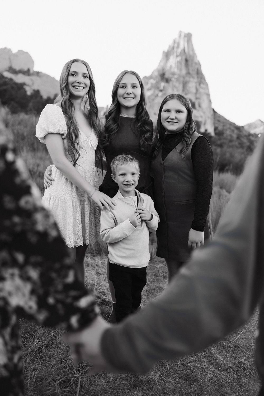A black and white photo series of a family posing together in an outdoor natural setting.