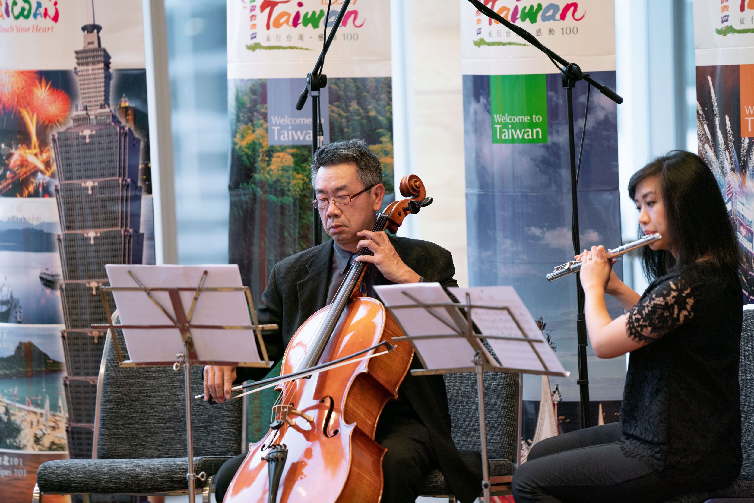 Musicians perform with cello and flute during cultural event.