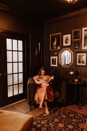 Romantic boudoir photoshoot in a vintage-style room with dark walls and ornate decor creates moody atmosphere.
