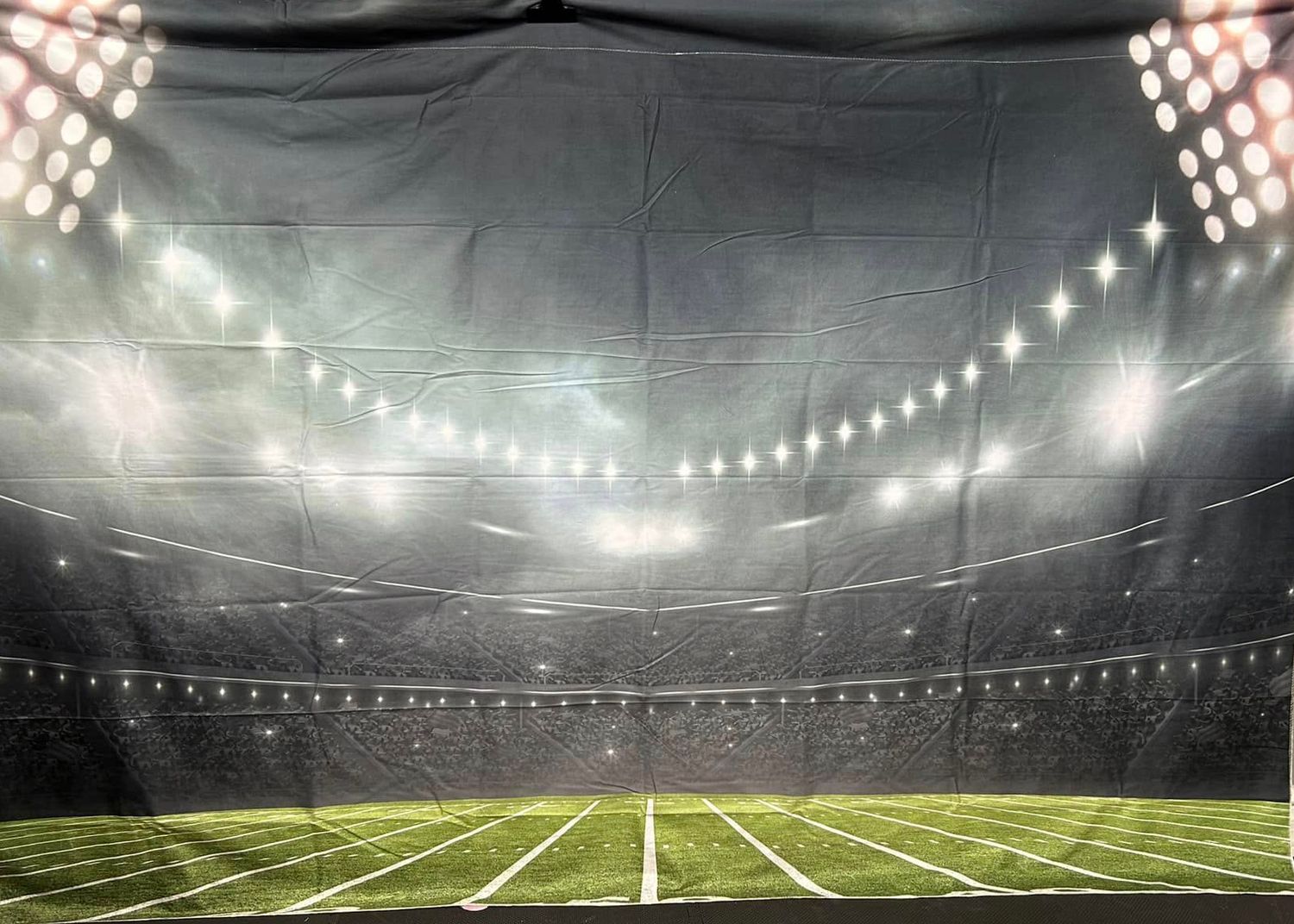 Football stadium backdrop with bright stadium lights and field markings.