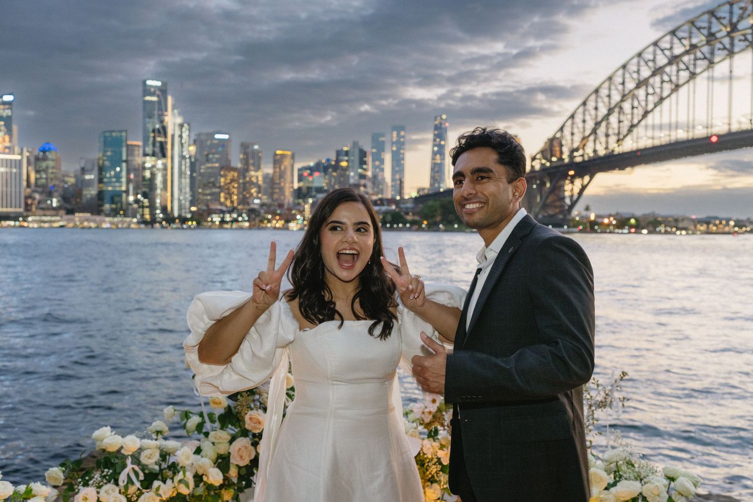 Candid moment of laughter shared between couple with city skyline behind.