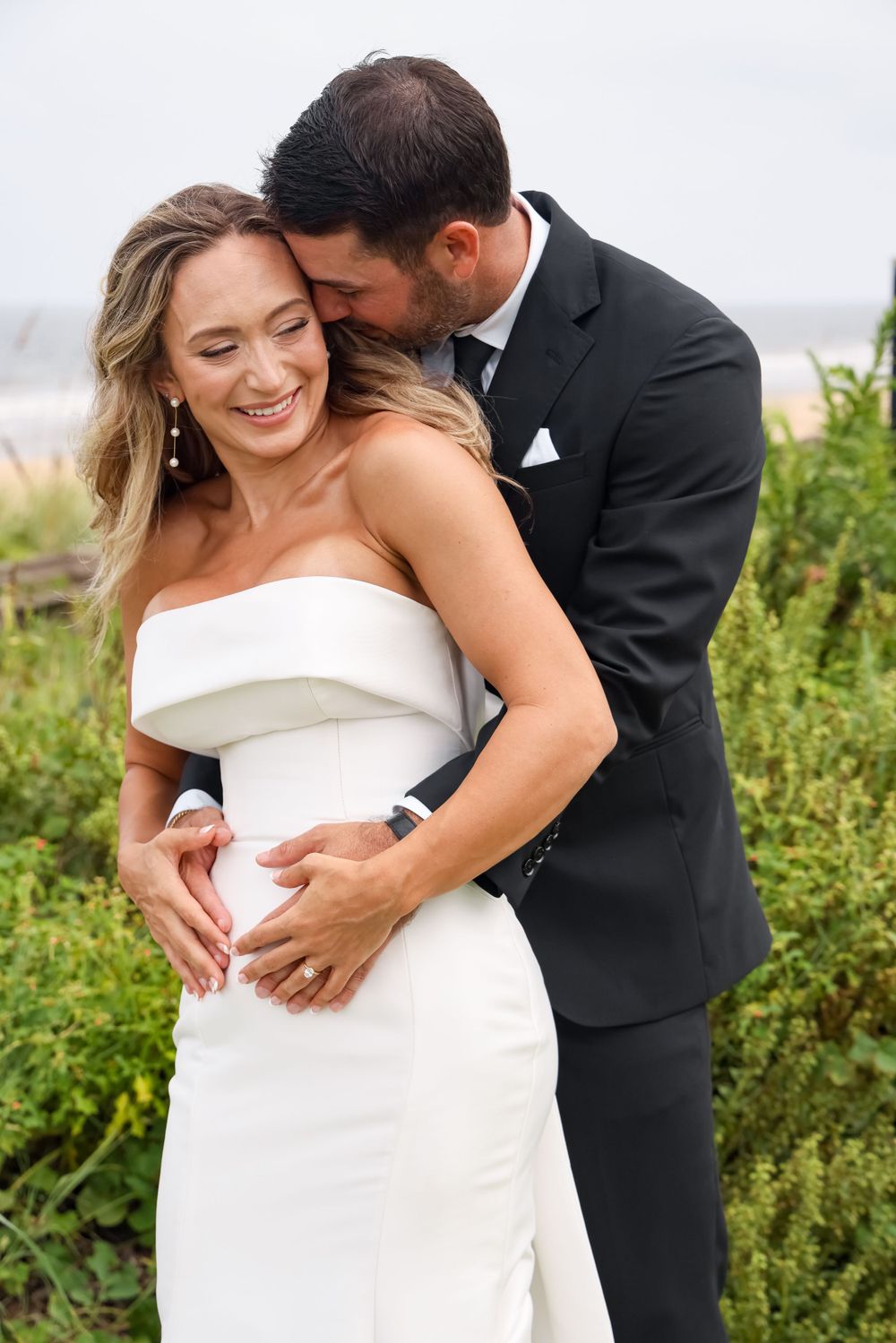 An intimate moment shared between newlyweds during their beach wedding photoshoot.