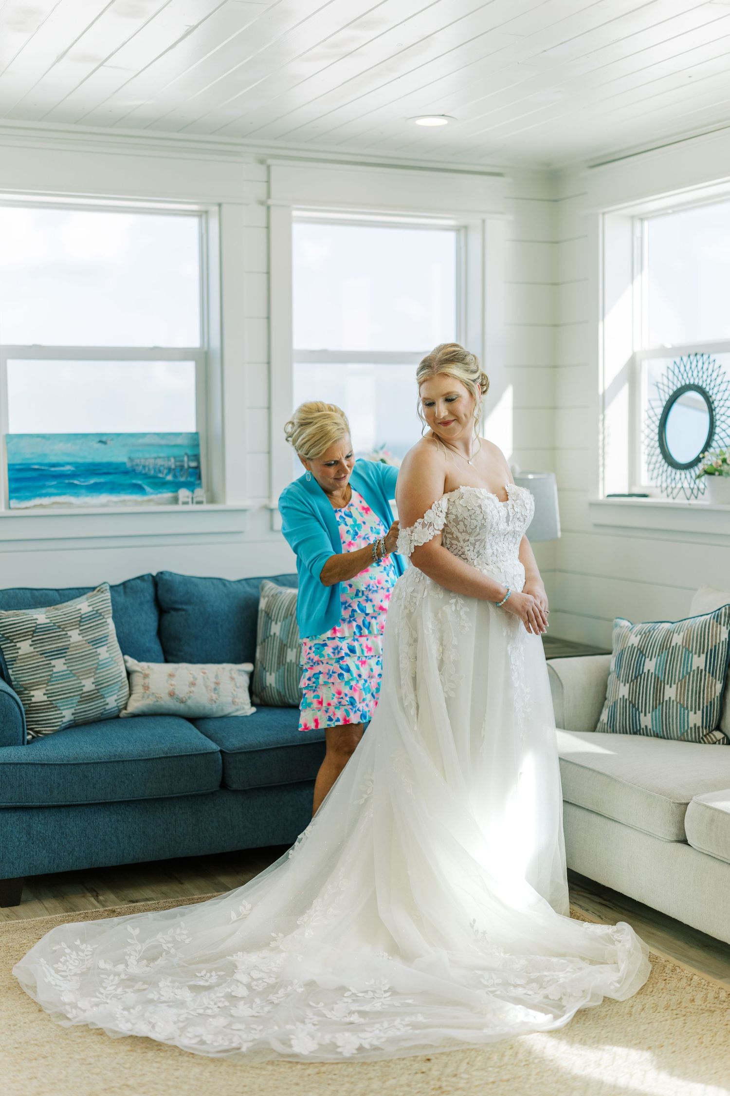 Final wedding dress preparations in a bright coastal room with blue accents.