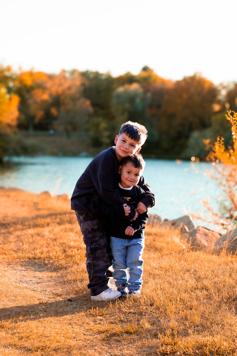 Two young brothers embrace at Cottonmill Park, Kearney, NE, during a Fall family session.