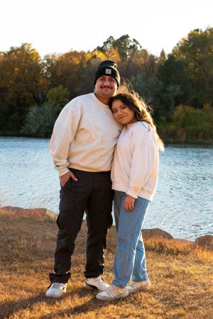 Young woman leans on husband’s shoulder by lake at Cottonmill Park, Kearney, NE.