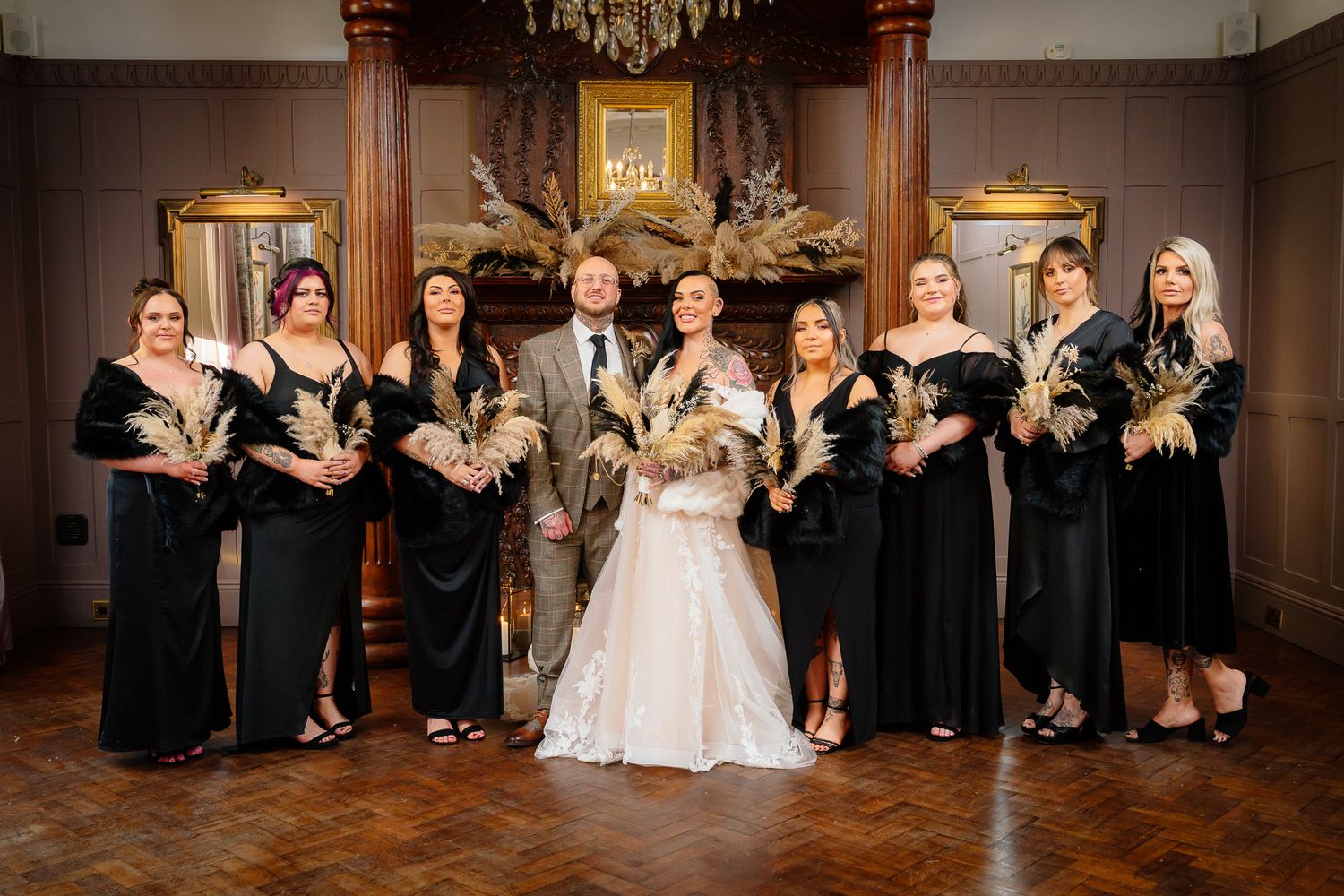 Wedding party members arranged in formal poses within a classic ballroom setting. Ellingham Hall