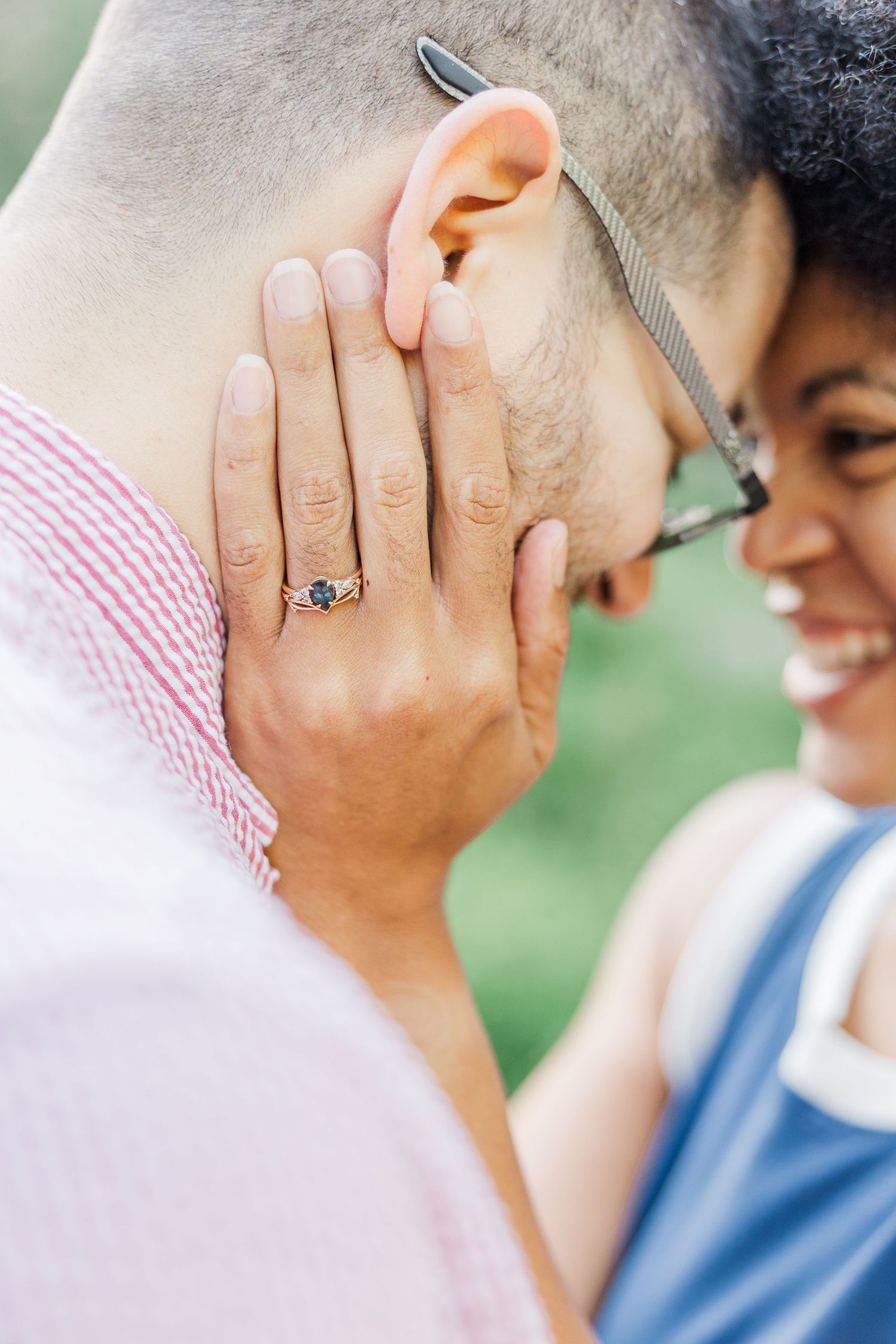 Close-up detail of engagement ring during intimate outdoor portrait session.