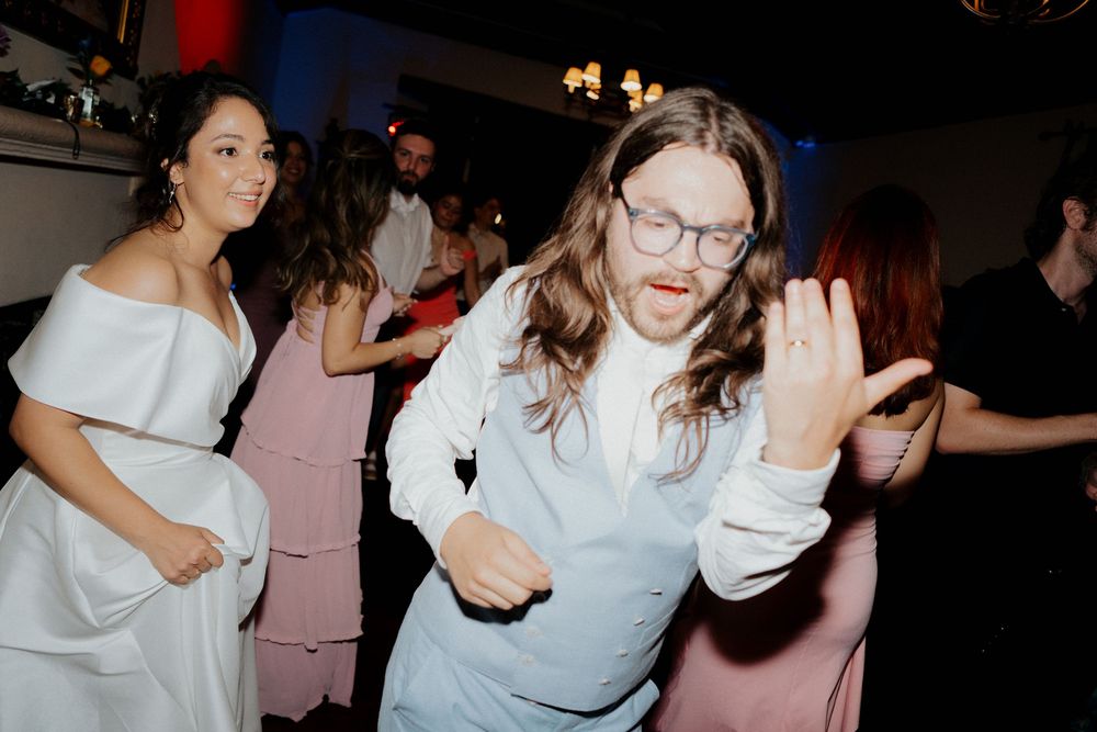 A group of people dancing and having fun at a party in a dimly lit room.