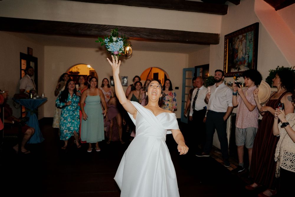 Wedding reception dance party with guests celebrating on a crowded dance floor under warm lighting.