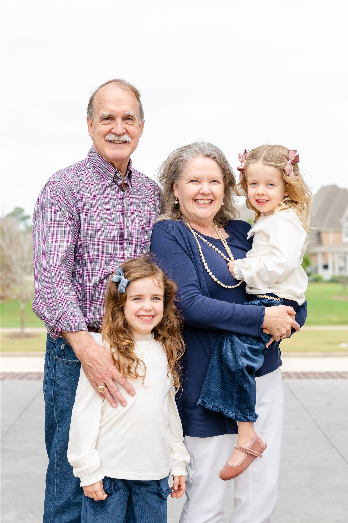 A family shares joyful moments together in coordinated navy and white outfits during an outdoor photoshoot in Conroe, Texas.