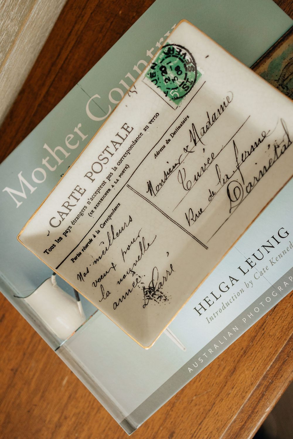 Four closeup shots of signatures and handwritten text in old books on a wooden surface.