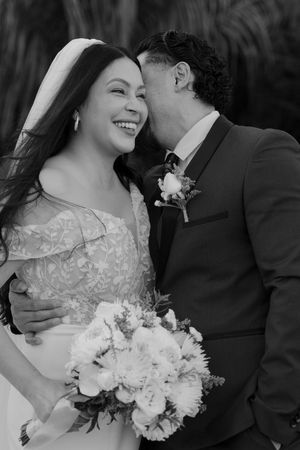 Black and white wedding photos show intimate moments between a couple with a white floral bouquet.