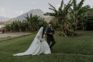Wedding celebration in a lush tropical garden with mountains and banana trees in the background.