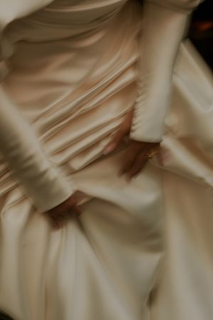 Close-up view of soft white fabric folds creating an abstract pattern with delicate shadows and textures.
