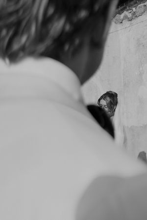 Black and white artistic wedding portrait showing an intimate moment against a light background.