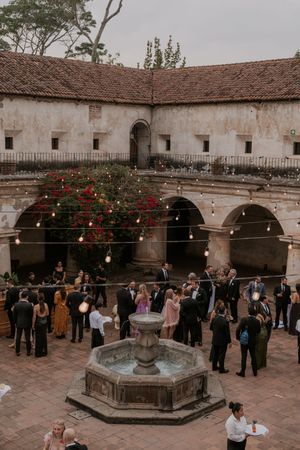 Historic Spanish colonial courtyard filled with guests during an elegant outdoor wedding reception.