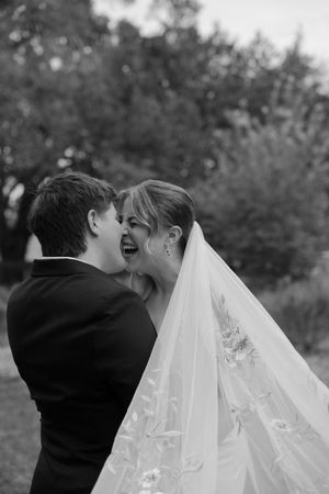 A romantic black and white wedding photo sequence showing a couple sharing a kiss under a flowing white veil.