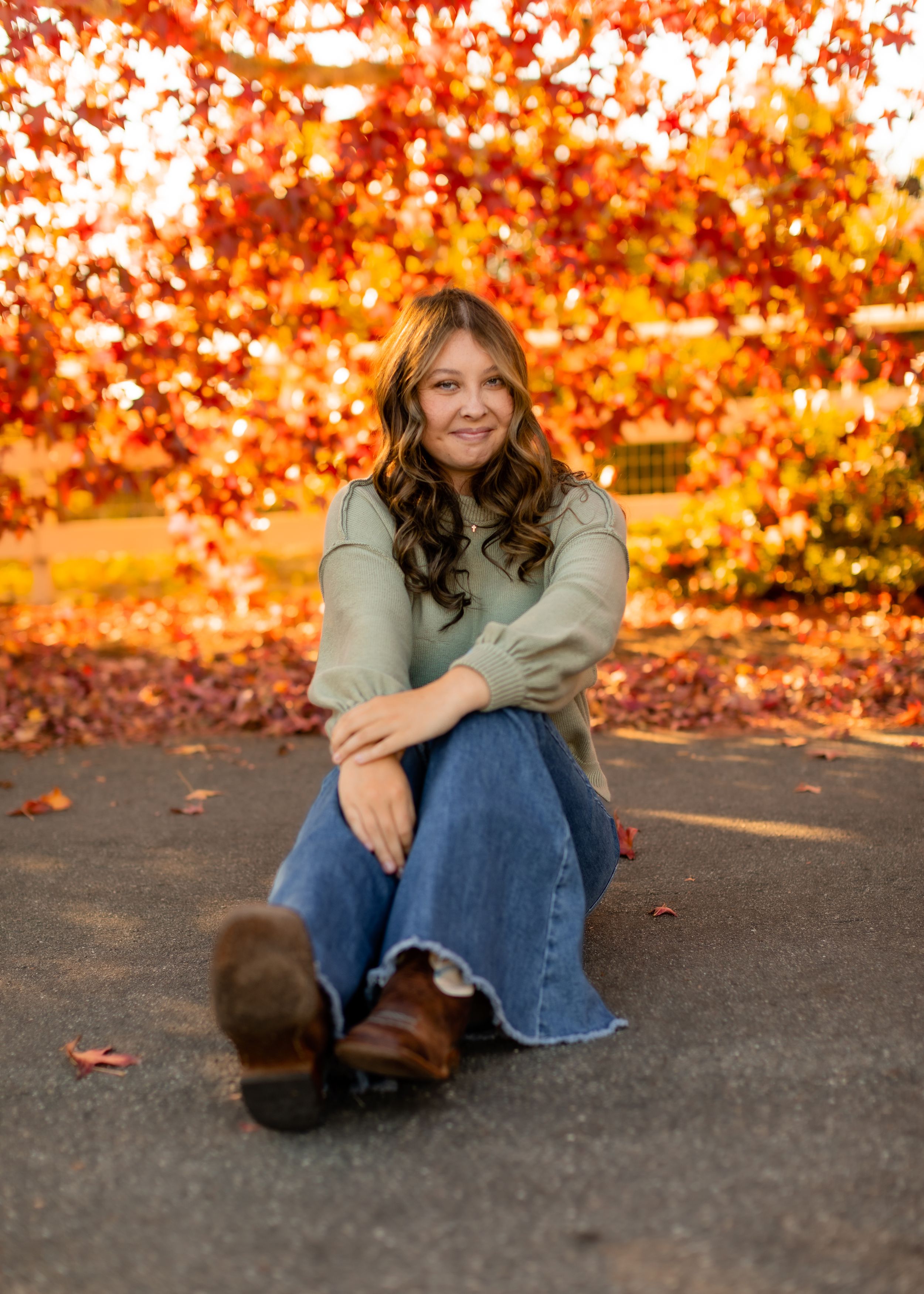 Autumn portrait with vibrant orange fall foliage in background.