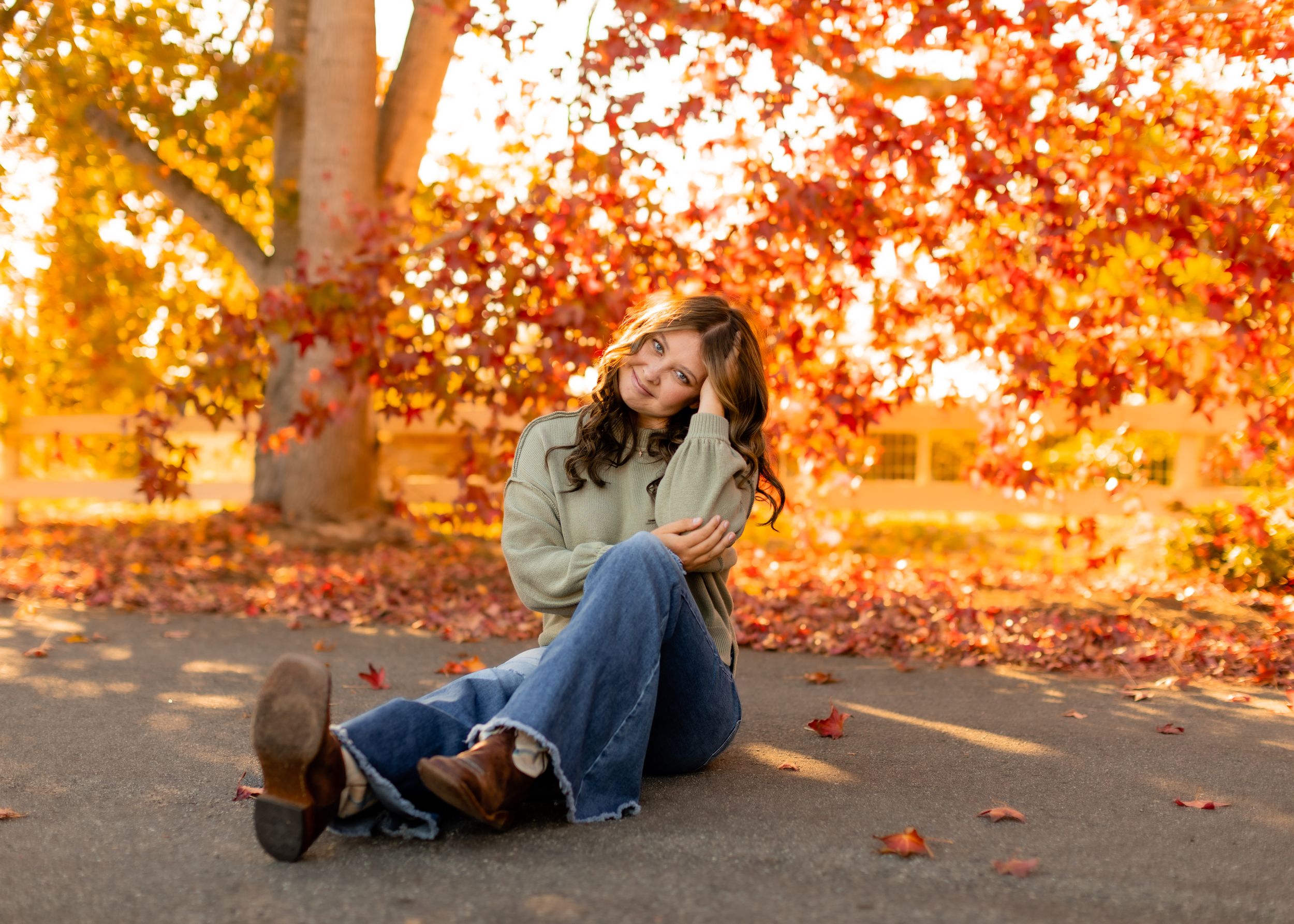 Casual fall portrait with bright orange autumn leaves in background.