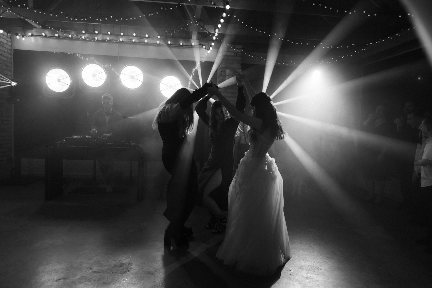 Silhouetted performers on stage with dramatic spotlights creating a moody concert atmosphere.