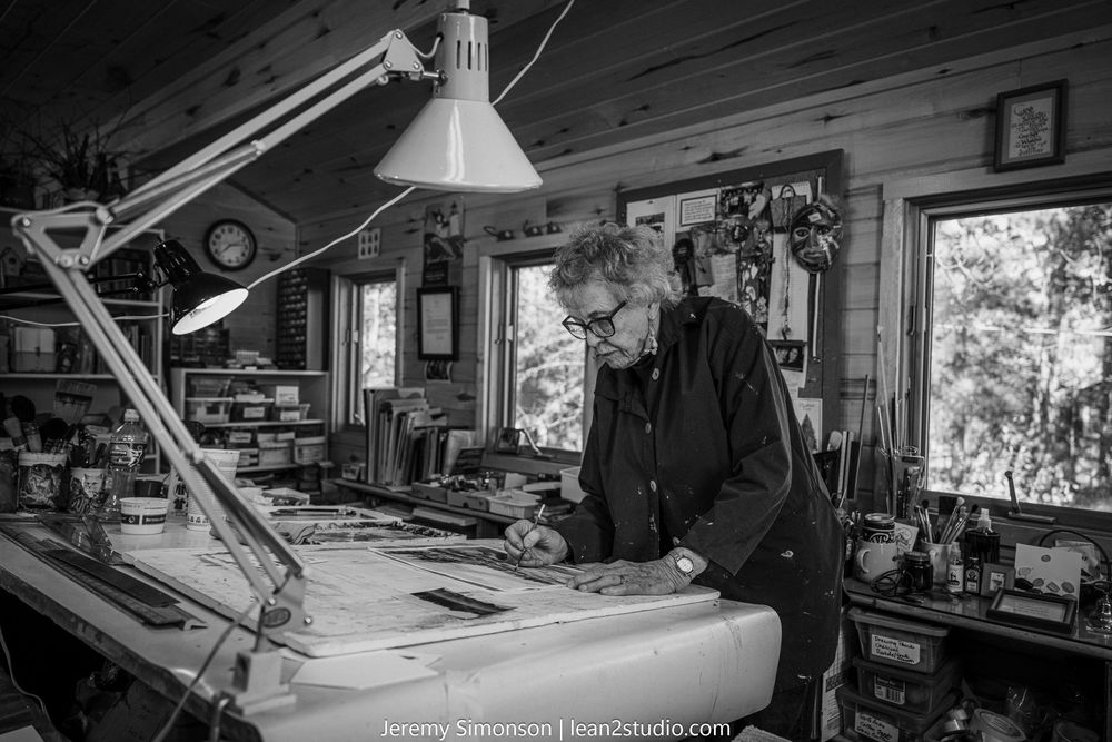 A woodworking workshop with various tools and equipment arranged along the walls and workbenches.