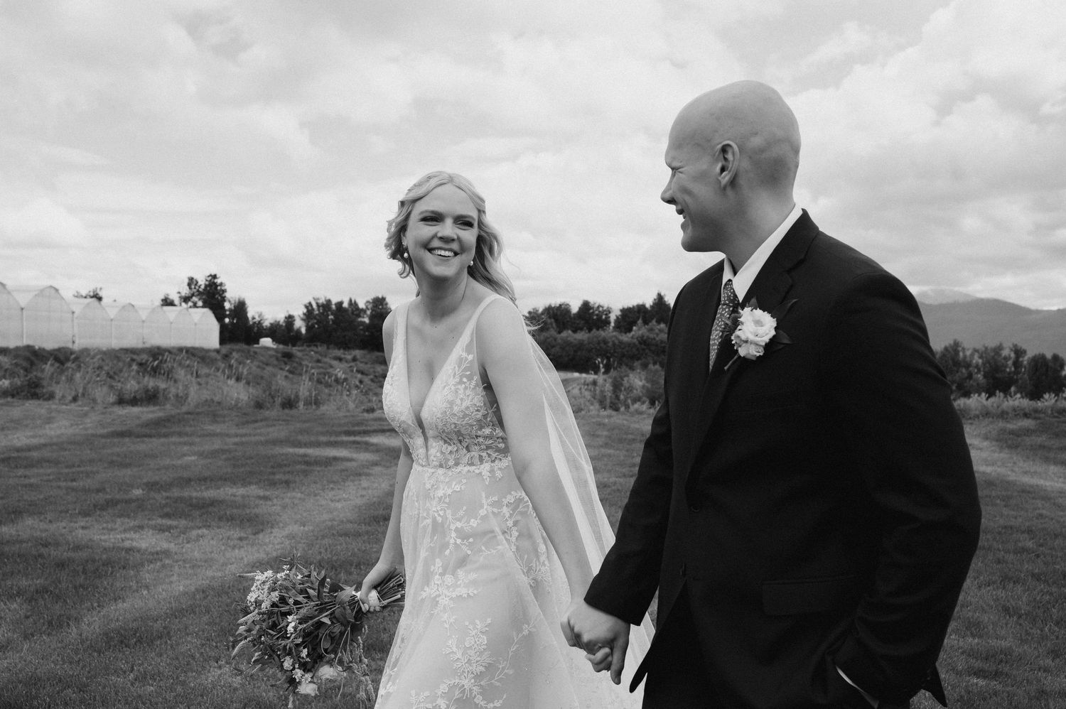 Black and white wedding portrait captured outdoors with mountains in background.