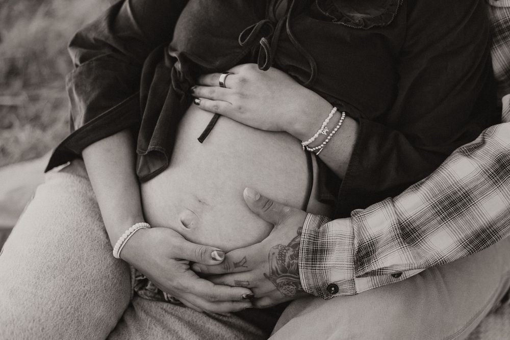 A series of intimate black and white photographs showing gentle embraces and tender moments between two people.
