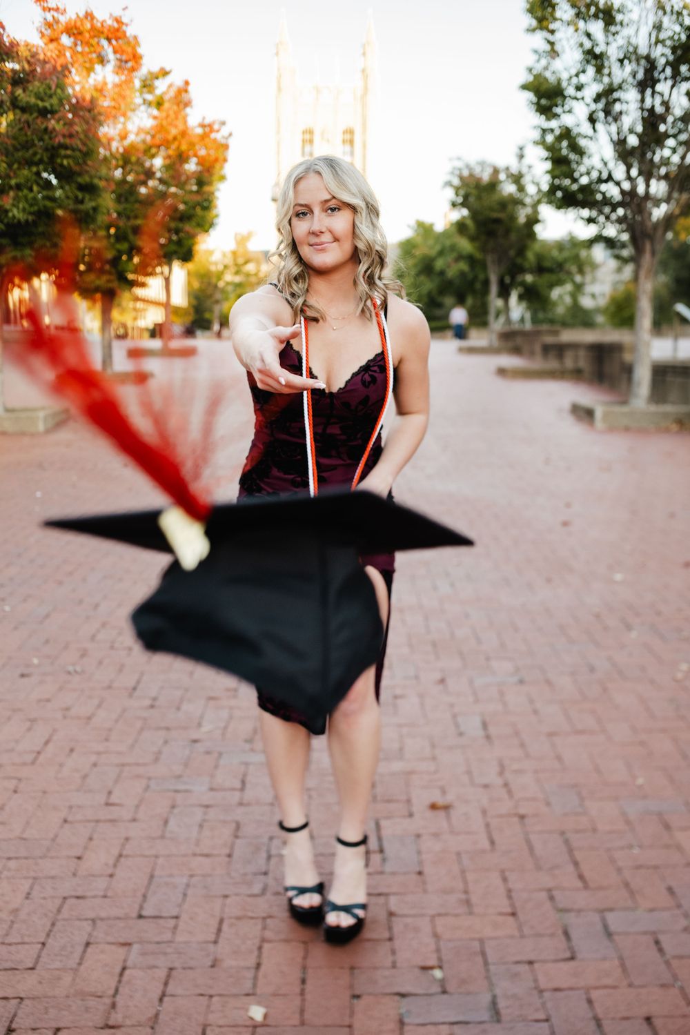 Graduation photo of a client throwing their cap at the camera on the Mizzou campus, capturing a celebratory moment.
