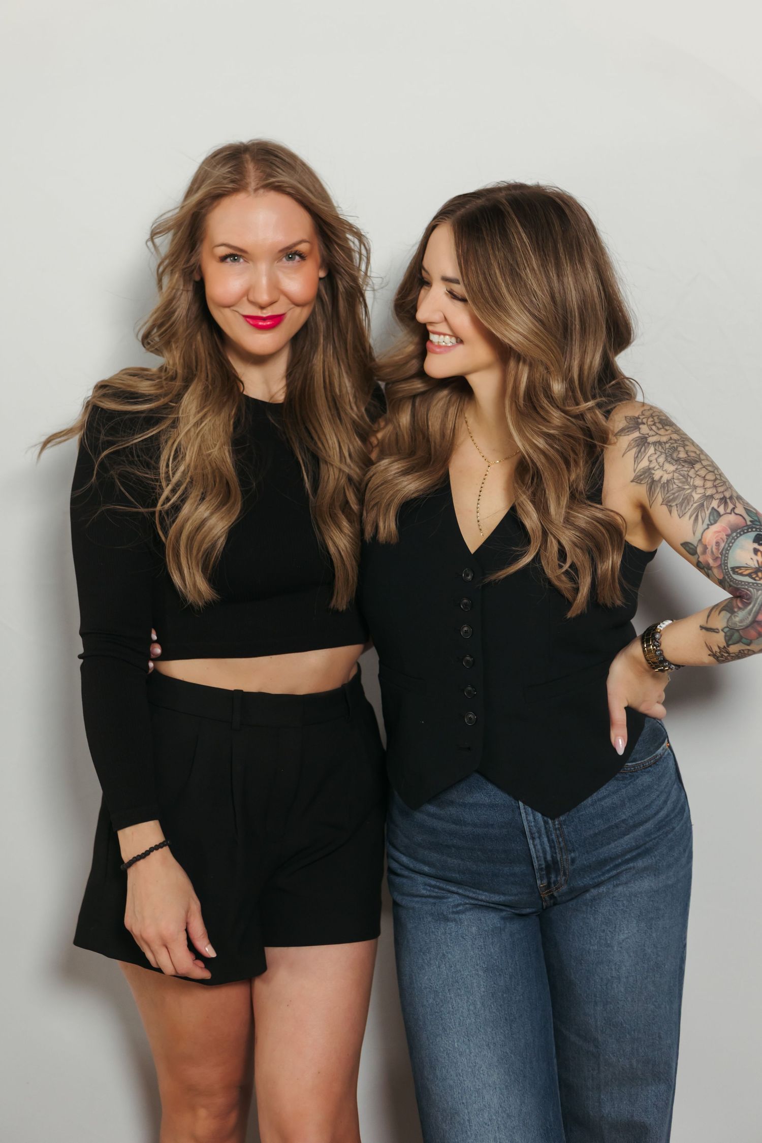 Two friends in casual outfits pose and laugh together against a white wall in a series of candid photos.