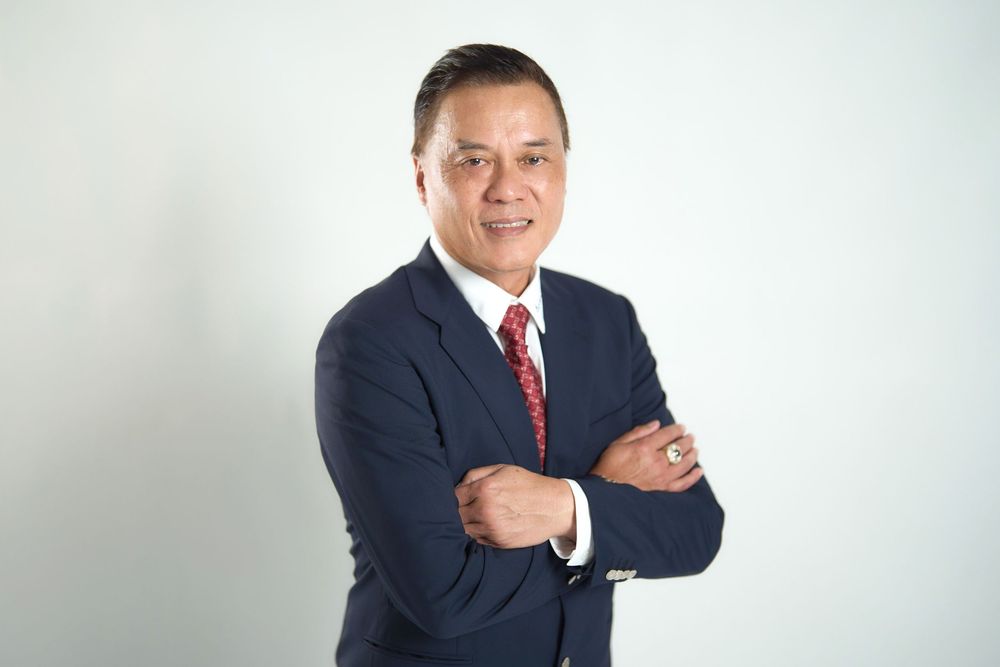 Corporate headshots of a businessman in a navy suit and red tie against a white background.