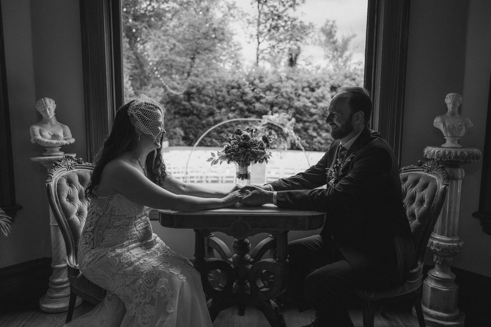 Artistic black and white silhouettes of wedding preparations through windows.