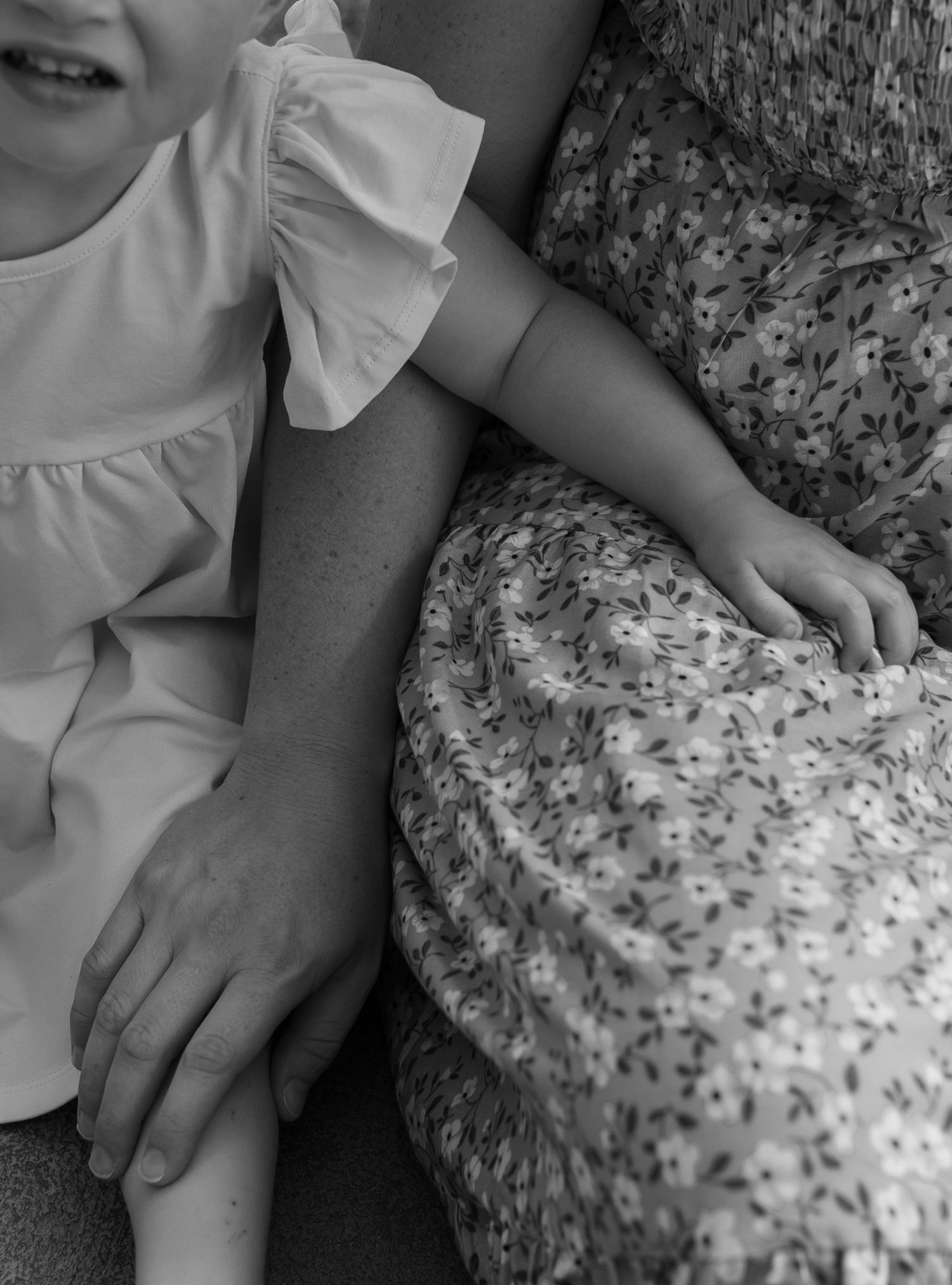 Black and white close-up details of hands and fabric textures during an intimate photo session.