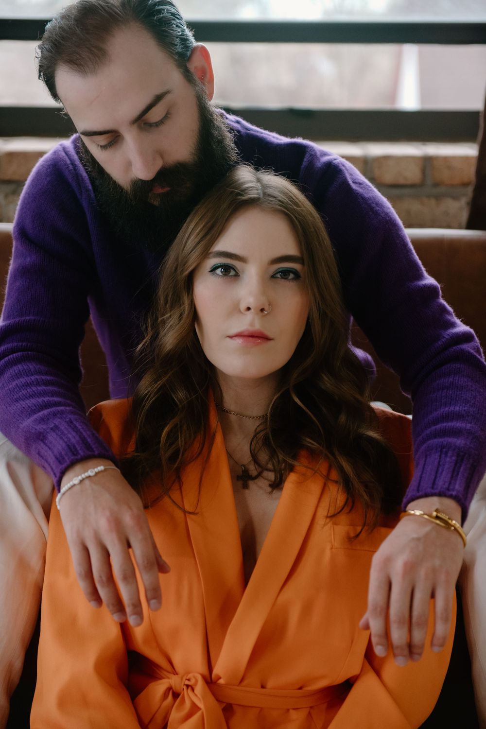 A series of intimate photos showing a person in an orange outfit with another person in purple sitting closely together.