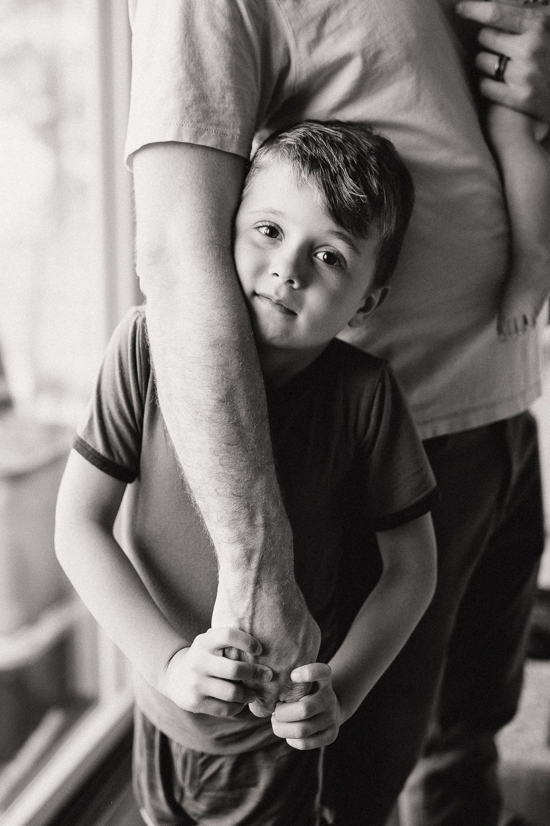 A black and white image showing a tender moment between parent and child.