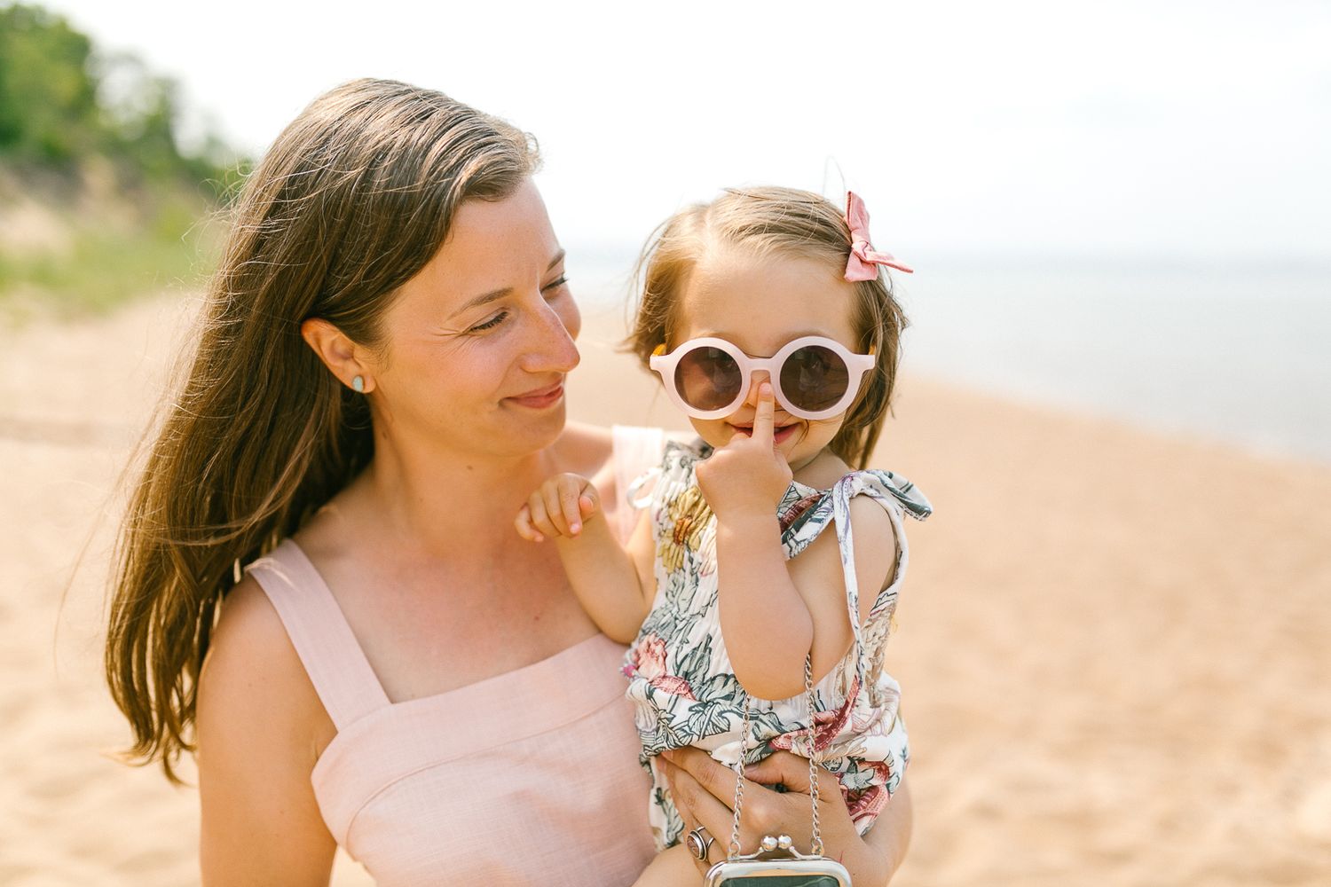 A mother and child share joyful moments together while playing on a sunny beach.