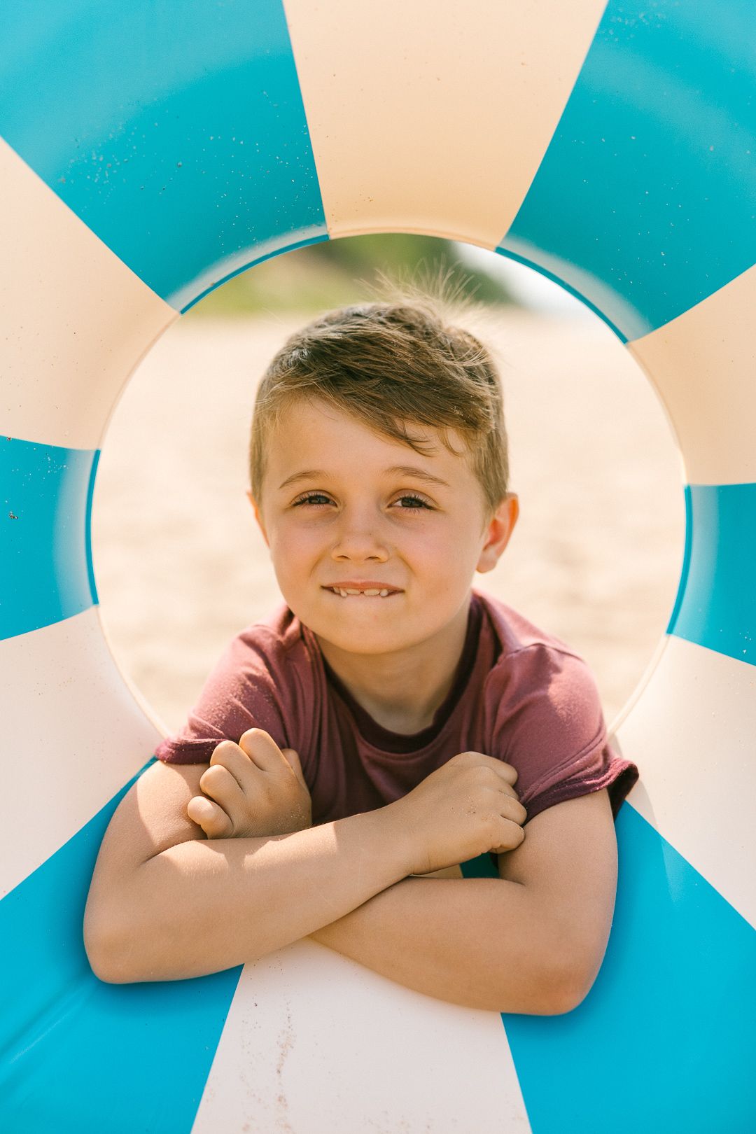 Child looking through circular blue and white geometric shapes in a fun photo sequence.