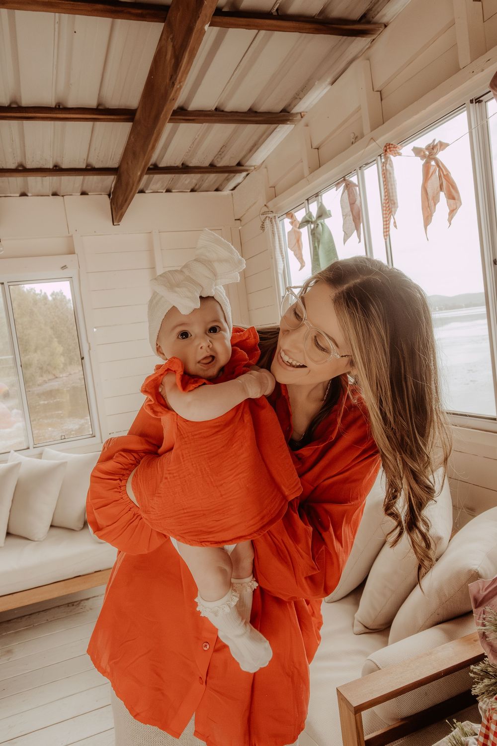 Joyful scene in a sunlit room with white walls and wooden beams.