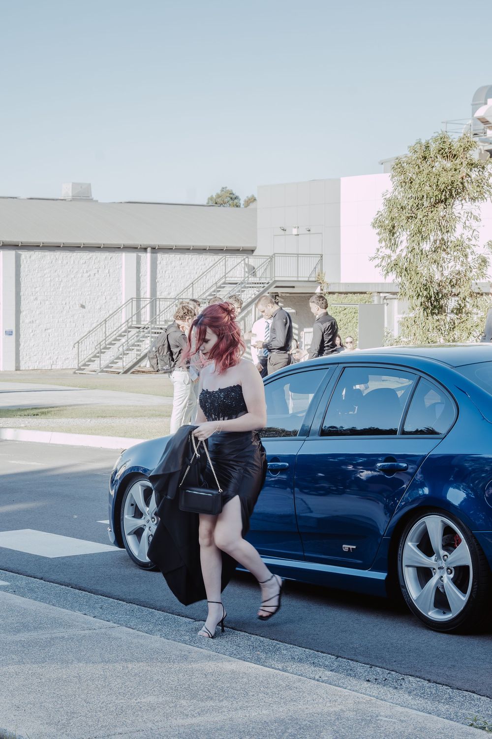 A black dress and blue car are featured in an artistic photoshoot sequence.