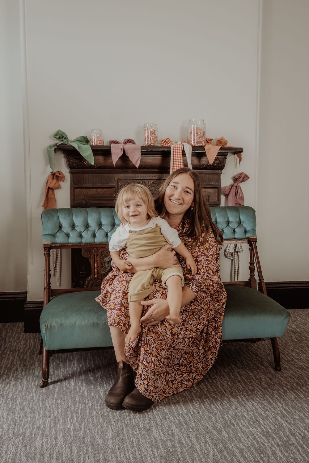 Vintage teal velvet settee with floral dress and natural light creates cozy indoor portrait setting at a hunter valley christmas photoshoot.