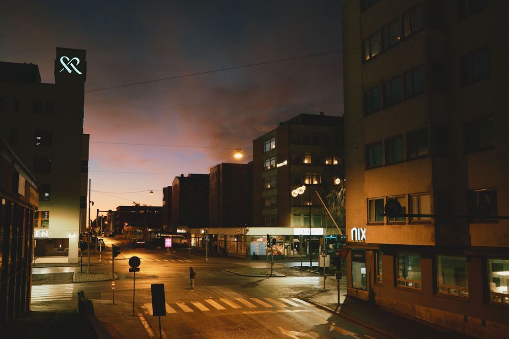 A series of nighttime urban street scenes showing empty roads and buildings illuminated by streetlights at dusk.