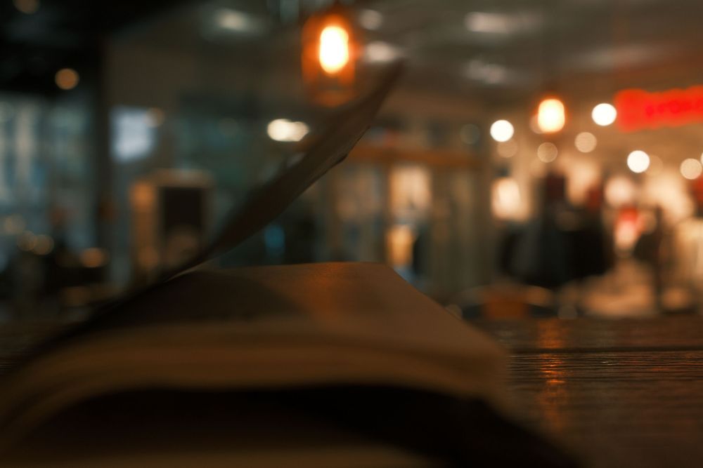 A dimly lit restaurant interior with warm glowing lights and bokeh effects creating an intimate ambiance.