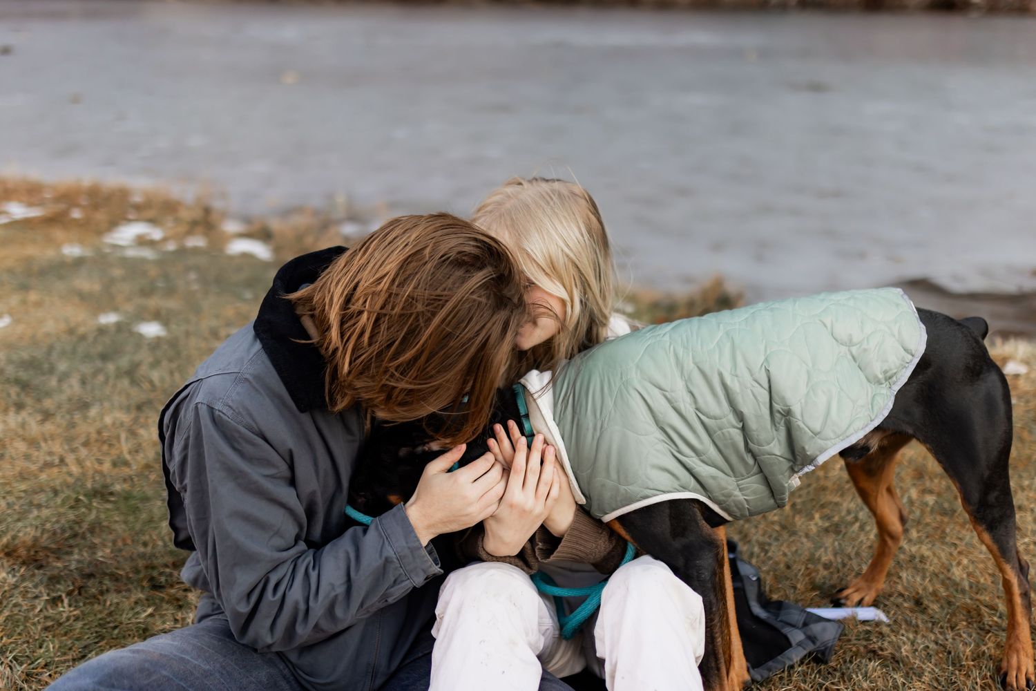 couple cuddling with their dog during an intimate winter couples photo session in Utah