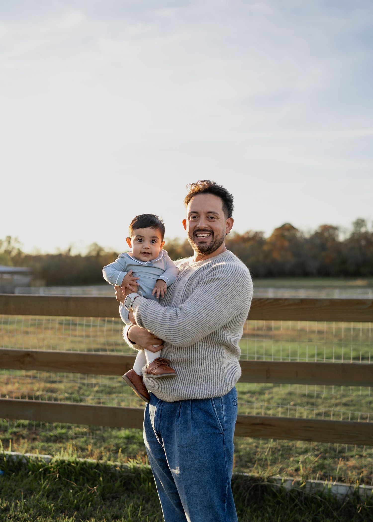 Family enjoying a festive Texas farm Christmas mini session, sitting on the bed of an old red Ford truck decorated with holiday greenery.