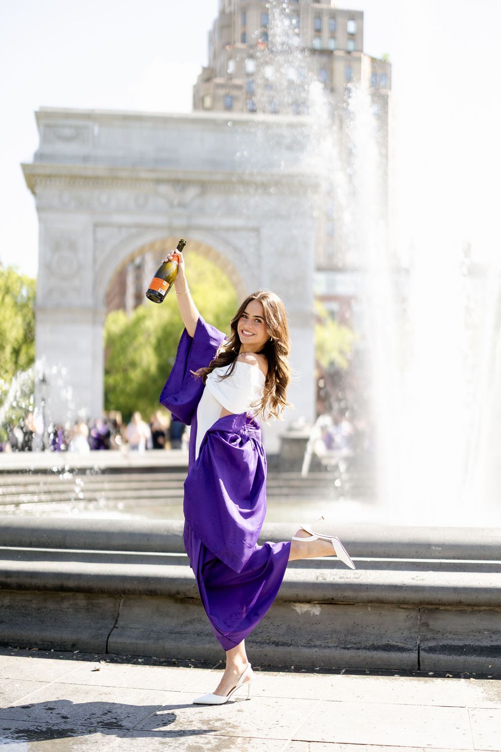 A series of graduation photos showing someone in a purple cap and gown jumping and celebrating near a fountain.