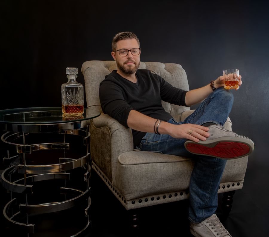 head shot of Chris Hinman, sitting in an armchair holding a glass of whiskey. Ceo of the best reputation