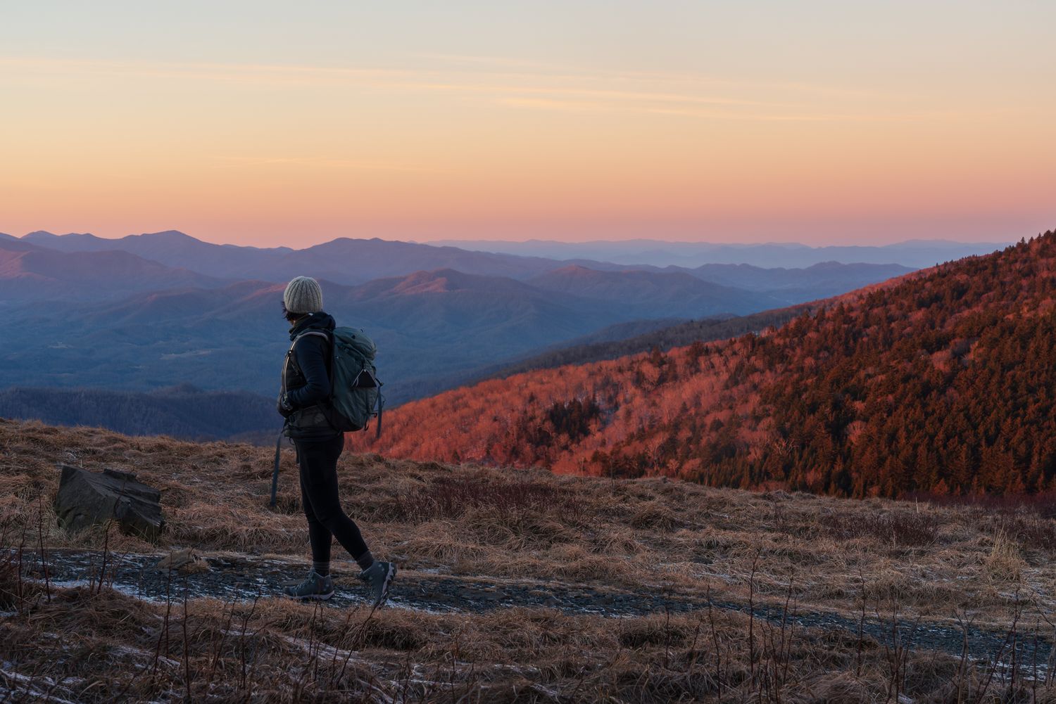 The photographer walks along a trail as the sun rises over the Blue Ridge Mountains