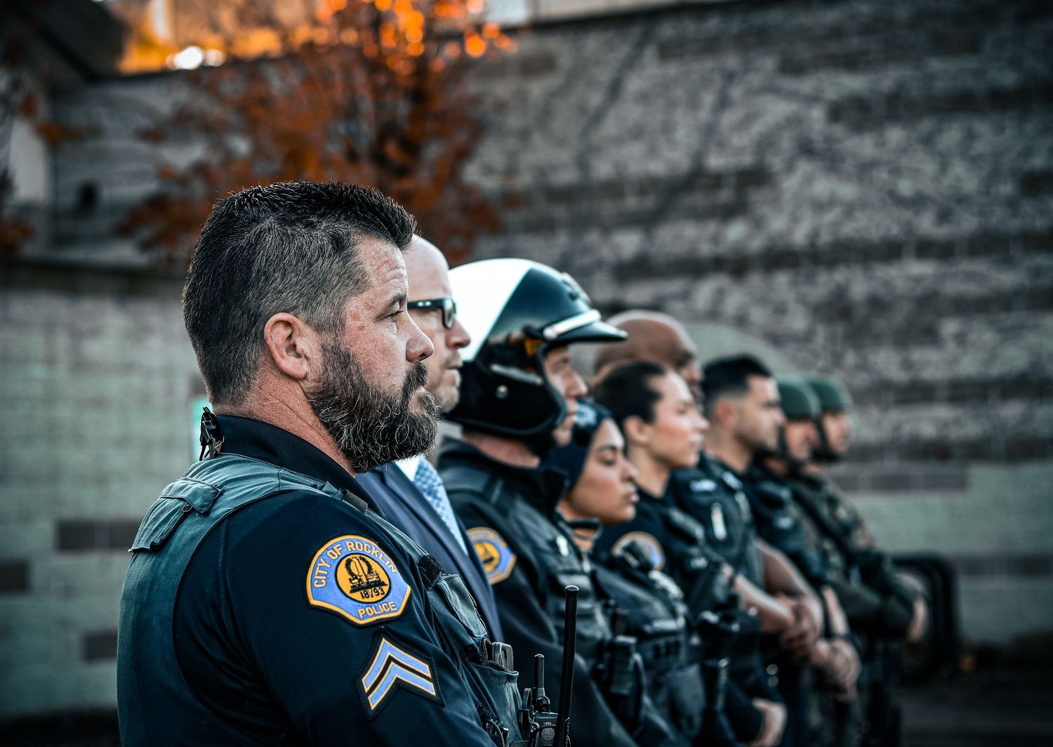 Police officers in tactical gear stand in formation during training.