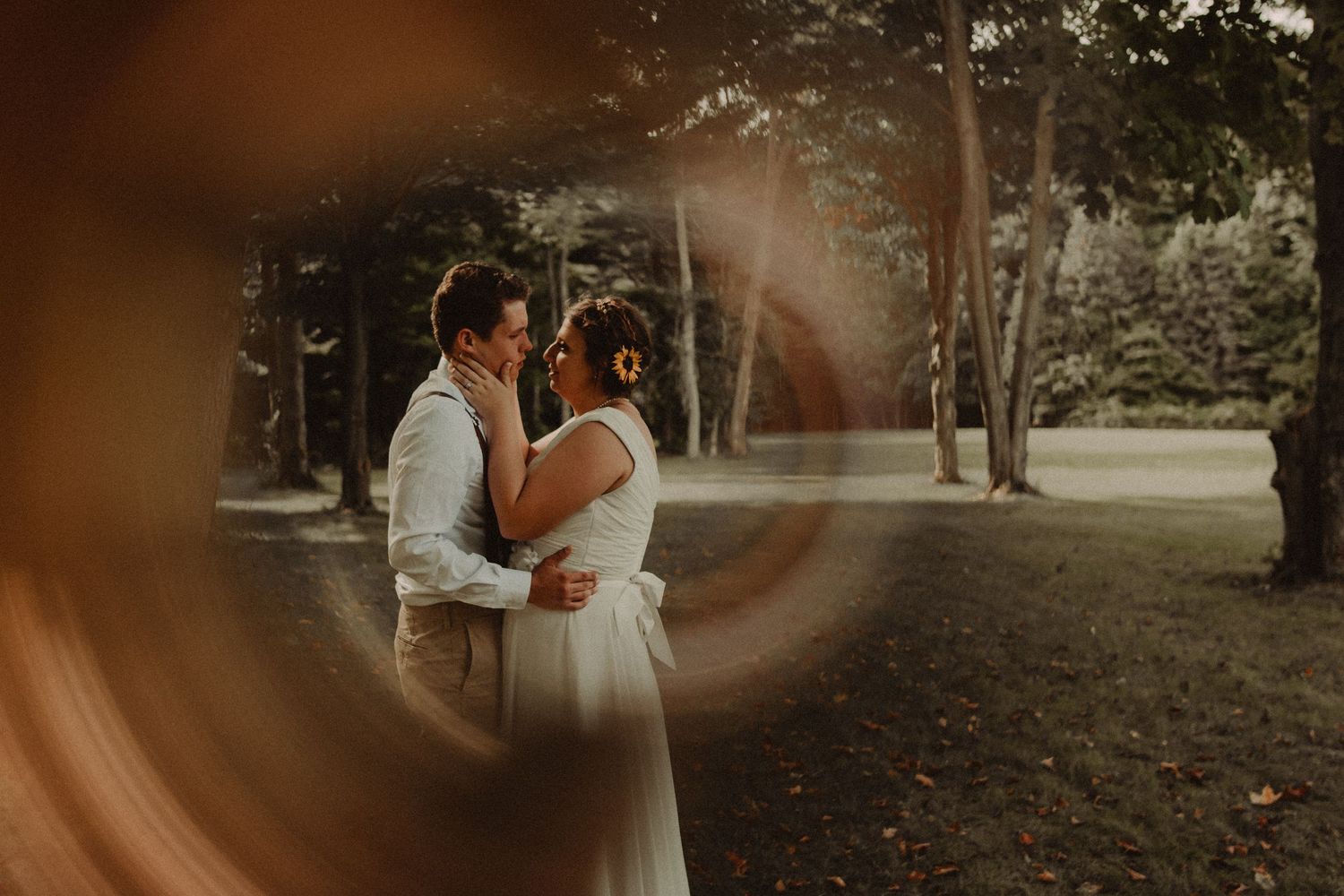 A romantic couple shares tender moments in a garden setting during their wedding photoshoot at sunset.