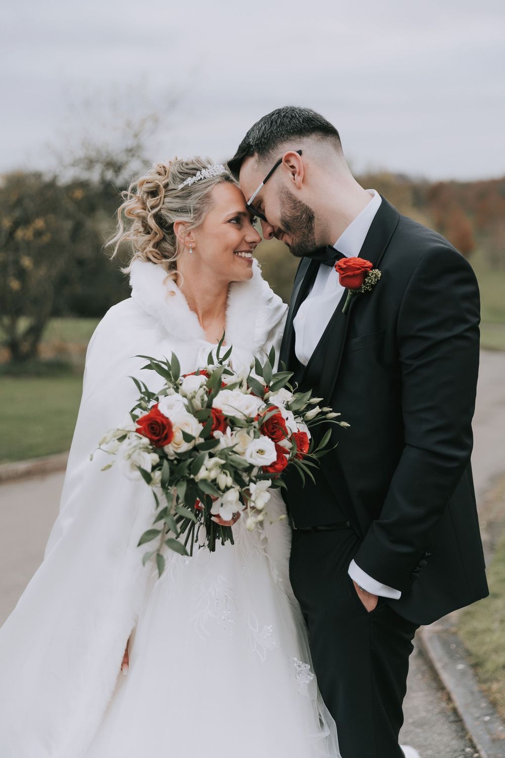 A romantic winter wedding photo series showing a couple in formal attire with red and white floral bouquet details.